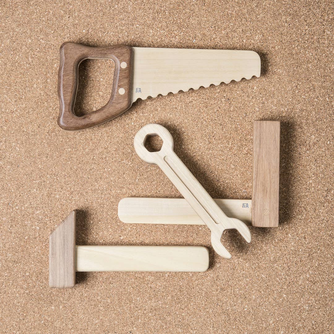 Children's wooden play tools including a saw, hammer, ruler and wrench.