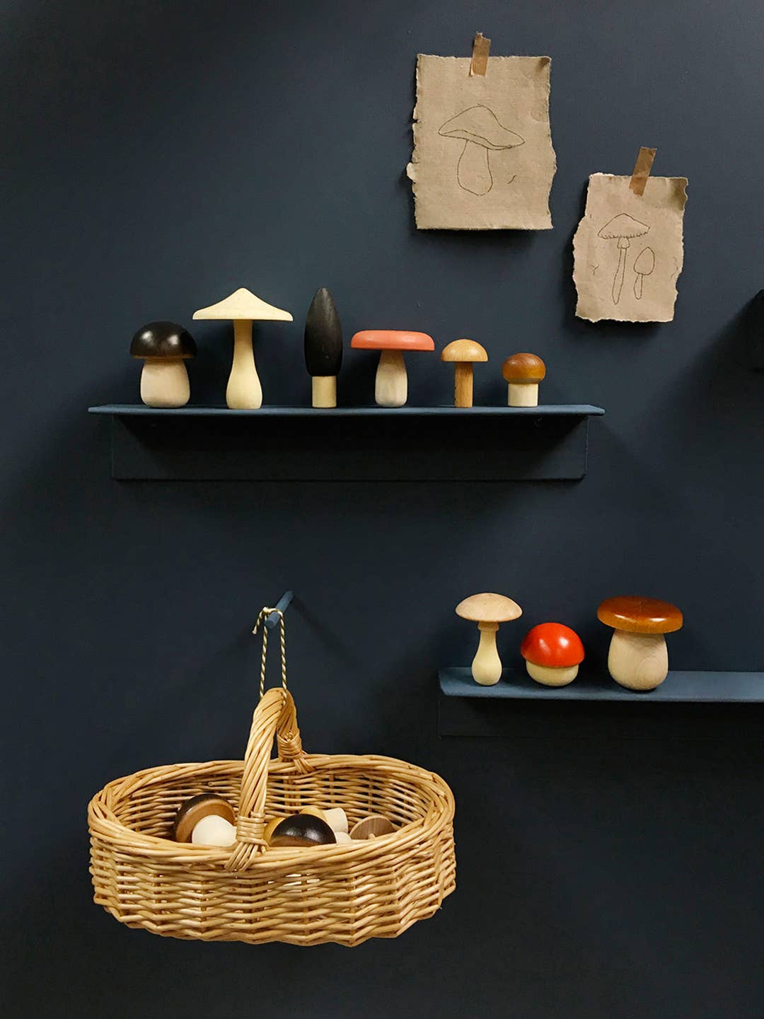 Wooden toy, decorative mushrooms on shelves against  with a woven basket hanging below.