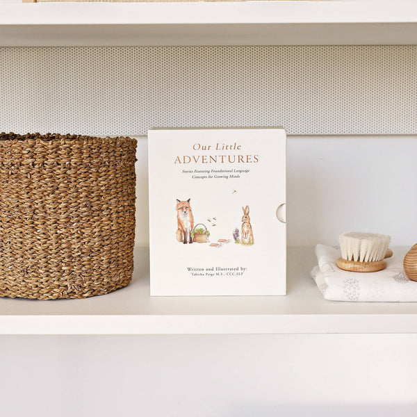 Collection of books titled 'Our Little Adventures' on a shelf with a woven basket.
