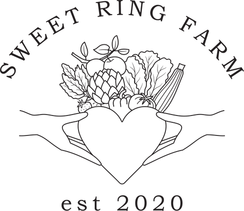 The official logo of Sweet Ring Farm featuring hands holding a heart crowned with fruits and vegetables.  This logo is inspired by ancient Irish Claddagh ring designs symbolizing love, loyalty and friendship.