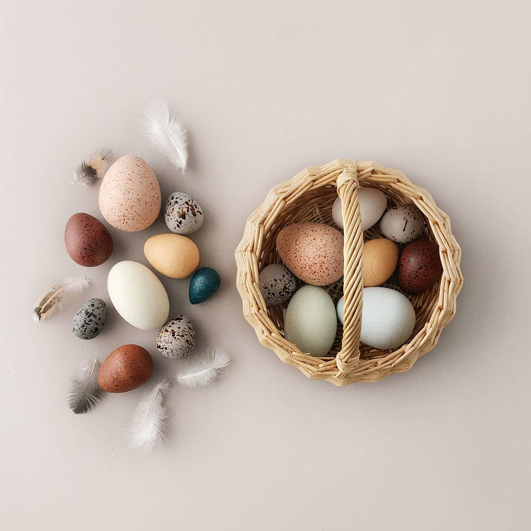 Assorted wooden toy eggs including in a woven basket for children ages 3 and up