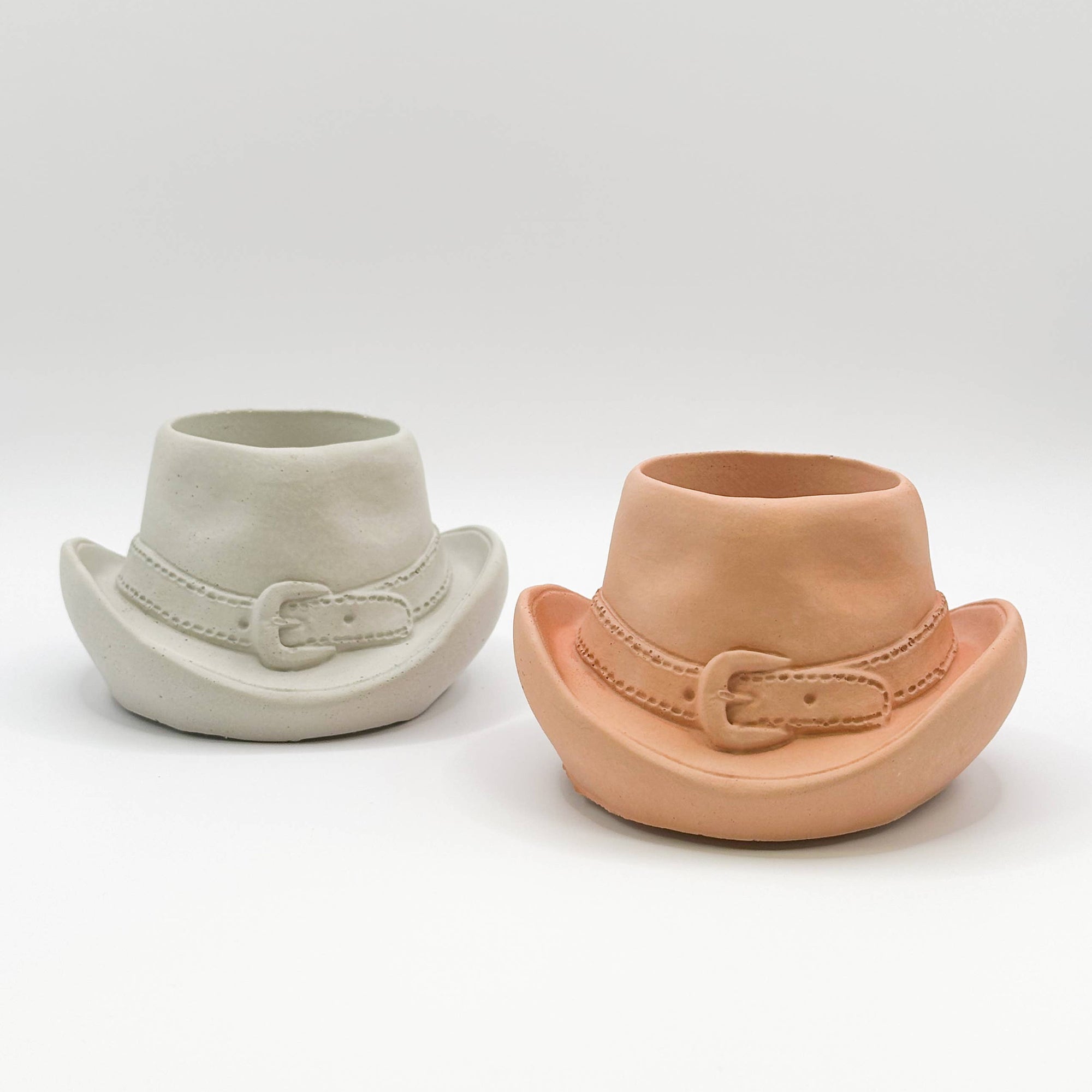 Two terracotta cowboy hat planters in concrete and brown terracotta